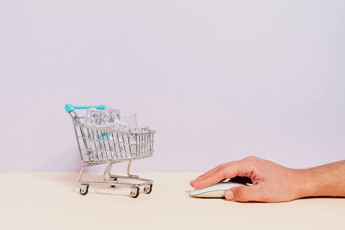 Hand Clicking on Mouse by Miniature Shopping Cart